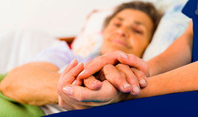 Enfermera sosteniendo mano de adulto mayor