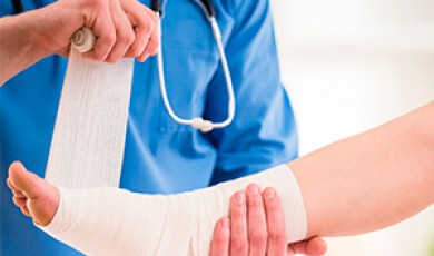 Foto de una enfermera colocándole vendas al pie de un paciente
